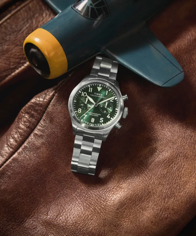 Timex TW2Y19100 Waterbury Ace Chronograph 41mm green dial stainless steel bracelet watch — styled with a model aircraft and leather flight jacket